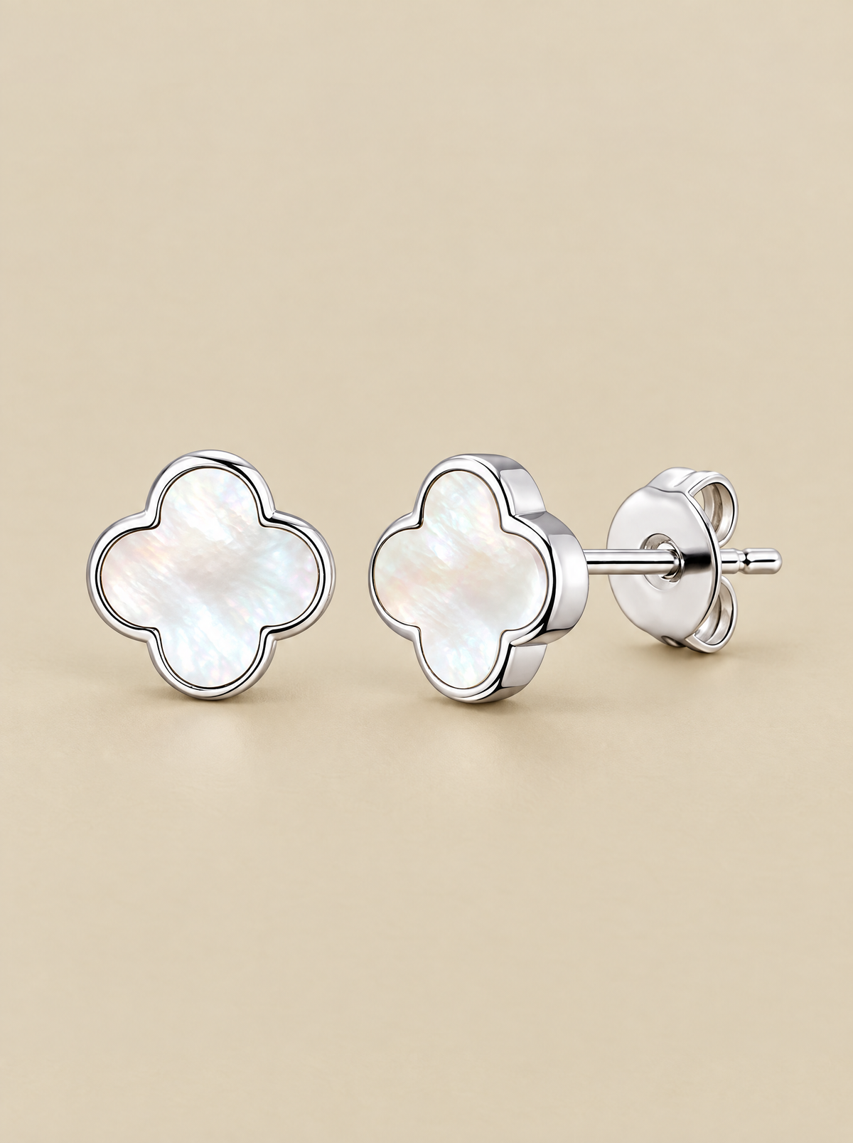 White Pearl Clover Stud Earrings on a beige background